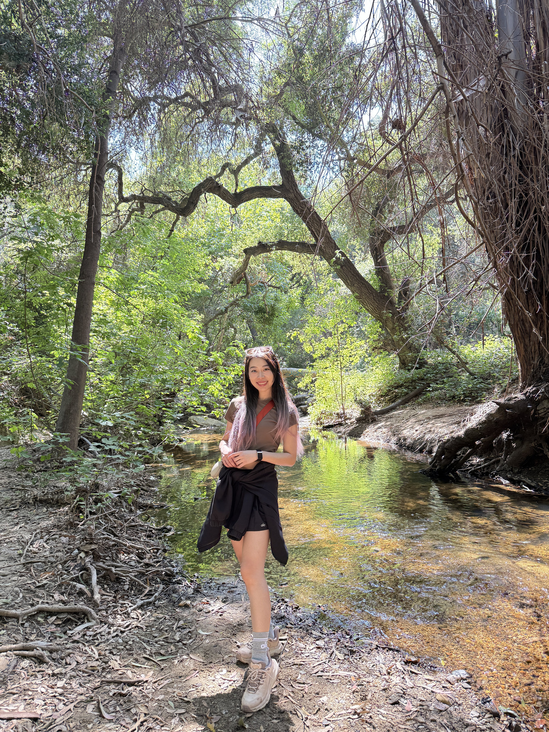 Rui Duan standing beside a wooded stream